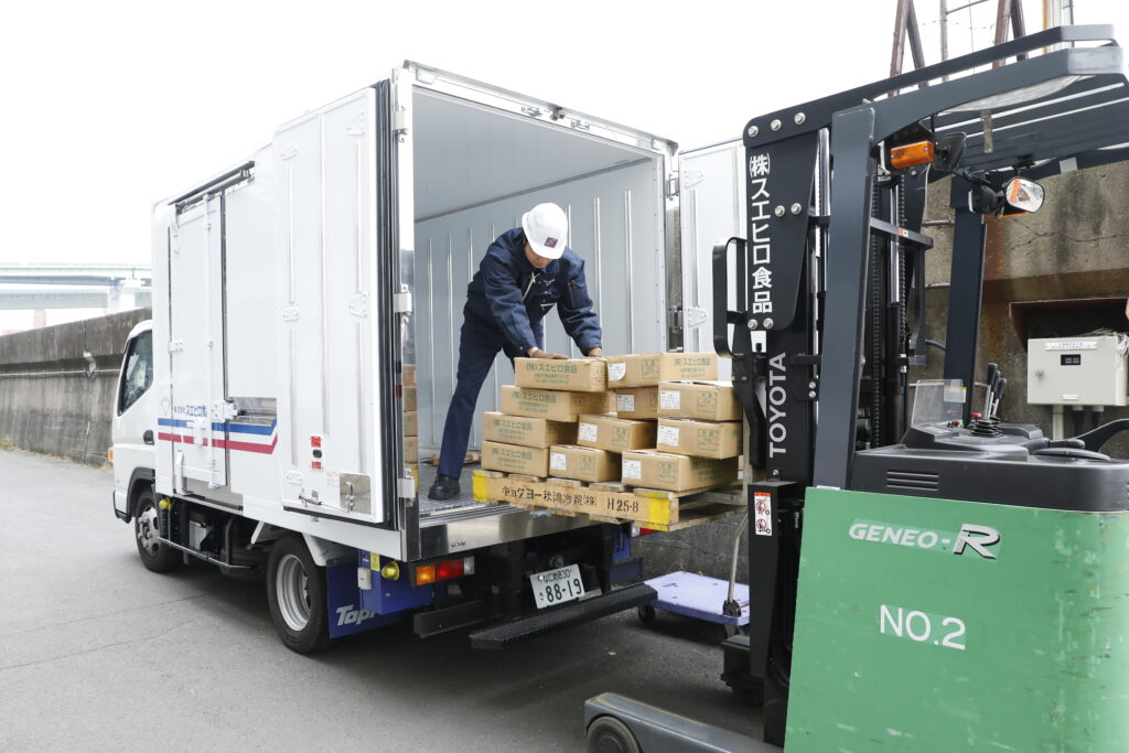 商品を集荷してトラックに載せている